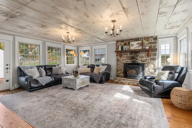 a living room with furniture a fireplace and a chandelier