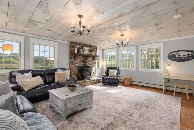 a living room with furniture chandelier and a fireplace