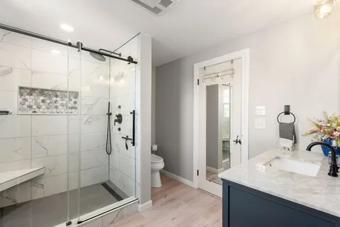 a bathroom with a granite countertop sink mirror and shower