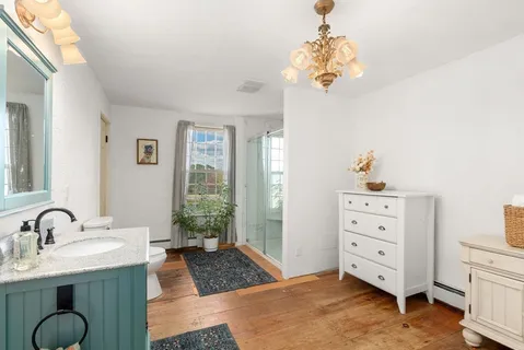 a bathroom with a granite countertop sink a mirror and a shower