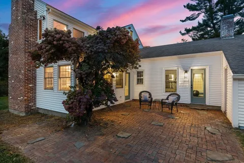 a view of a house with backyard and sitting area