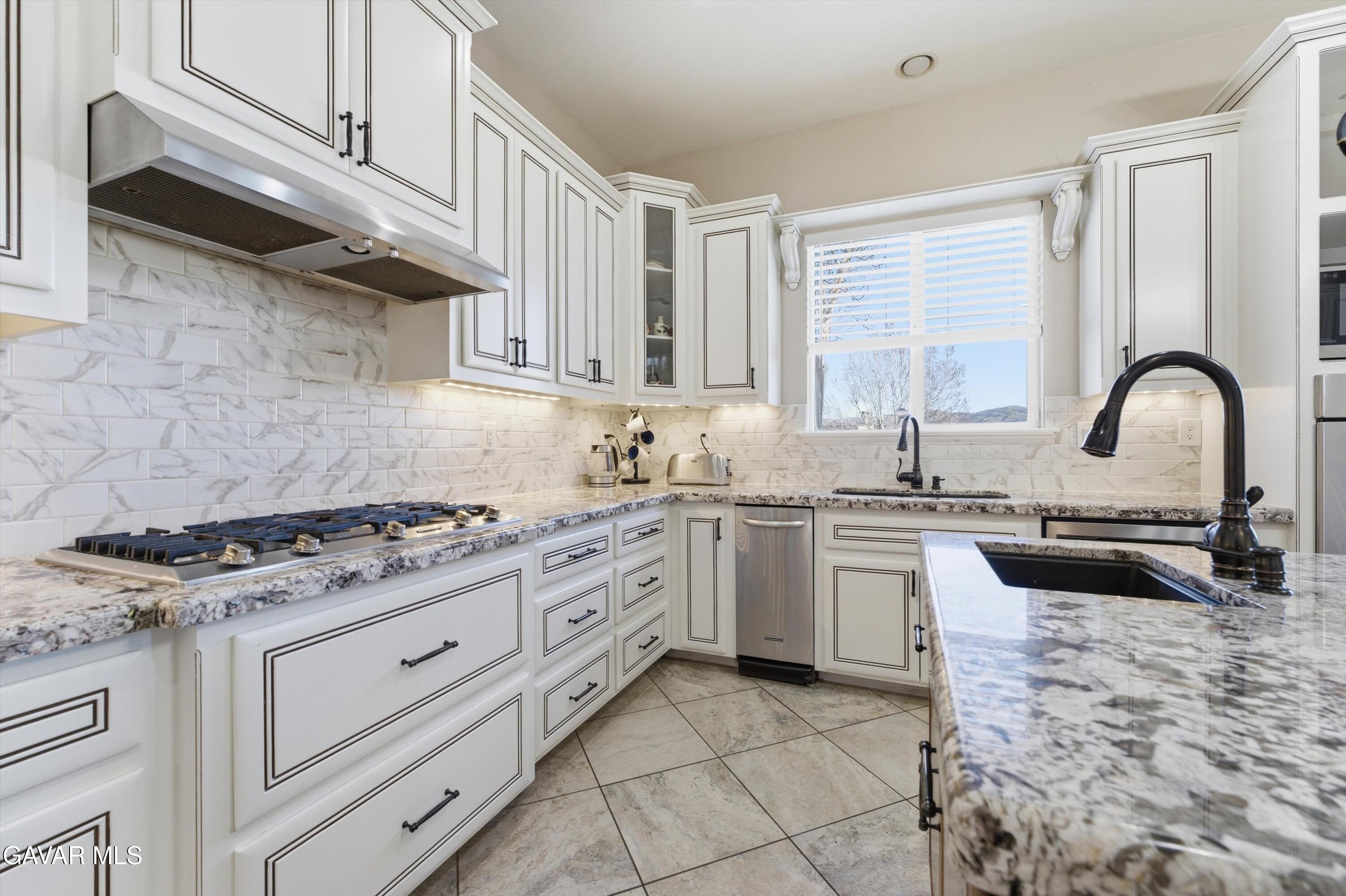 109 Oak Place Tehachapi, CA 93561 - Photo 13 of 25 a kitchen with granite countertop a stove sink and cabinets