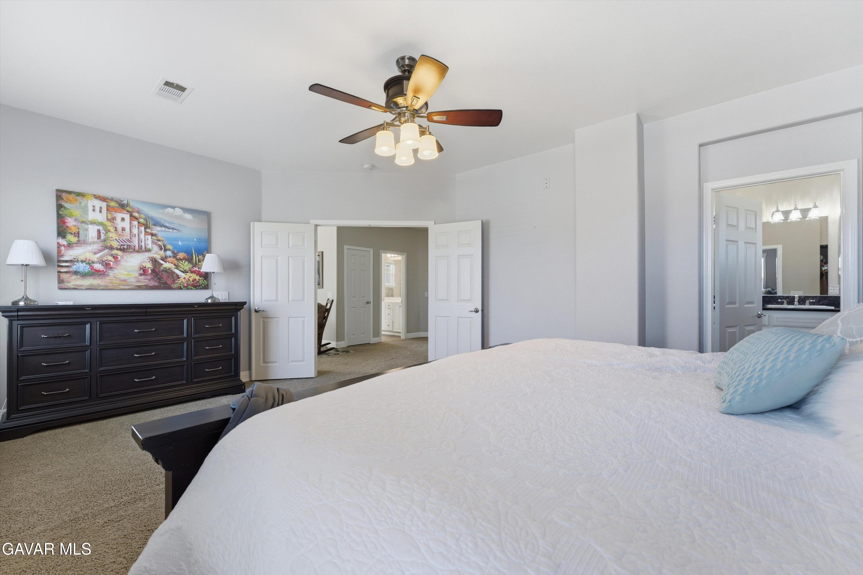 109 Oak Place Tehachapi, CA 93561 - Photo 19 of 25 a bedroom with a bed and a chandelier