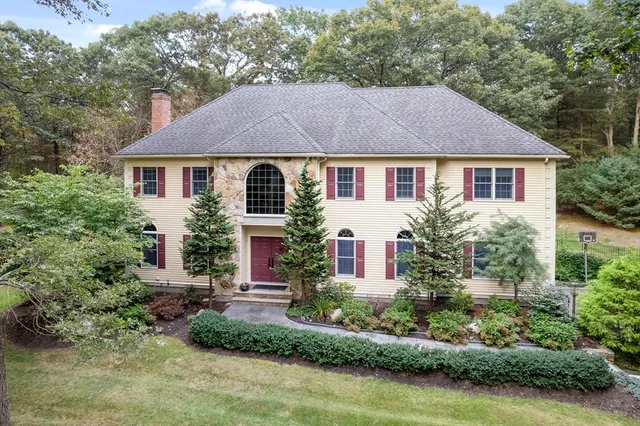 a front view of a house with a yard and potted plants