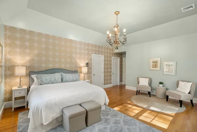 a bedroom with a bed and a chandelier