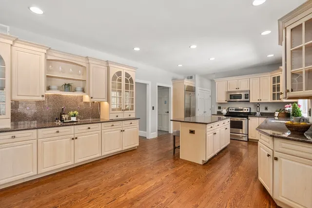 a large kitchen with stainless steel appliances granite countertop a stove and a sink