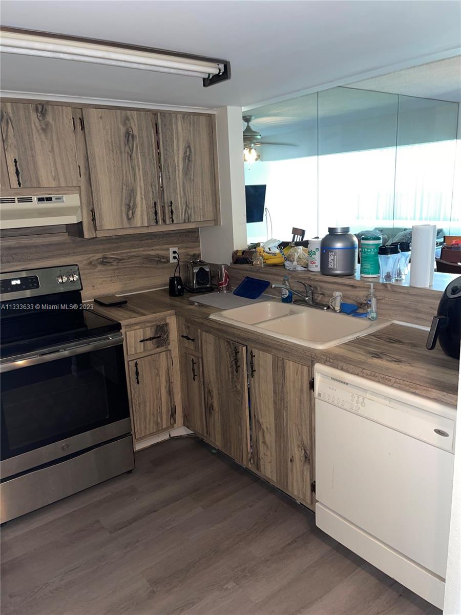9500 Southwest 3rd Street, Unit C258 Boca Raton, FL 33428 - Photo 6 of 13 a kitchen with a stove a sink and a microwave