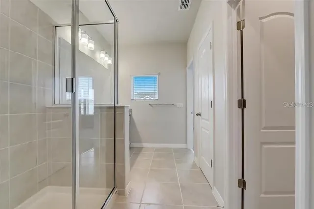 a bathroom with a glass shower door and a glass door