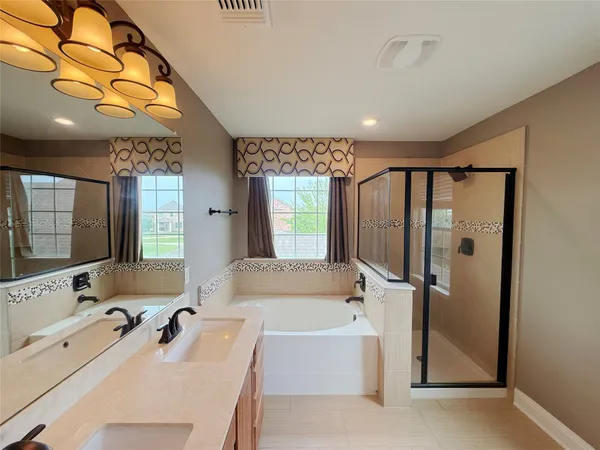 a bathroom with a tub a sink and mirror