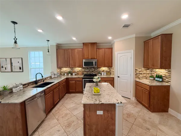 a kitchen with stainless steel appliances granite countertop a stove and a sink