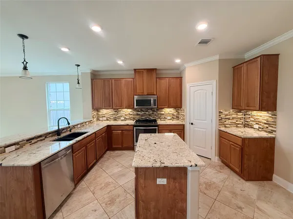 a kitchen with granite countertop stainless steel appliances and wooden cabinets