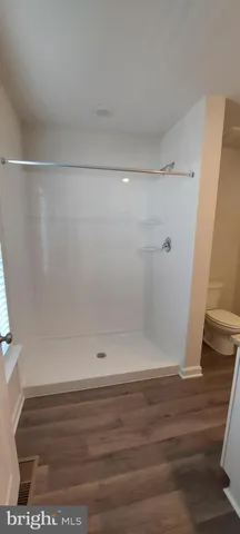 a bathroom with a granite countertop sink and a toilet