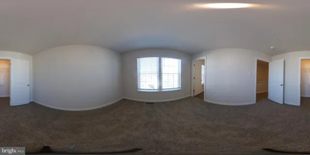 a view of a hallway with wooden floor and cabinet