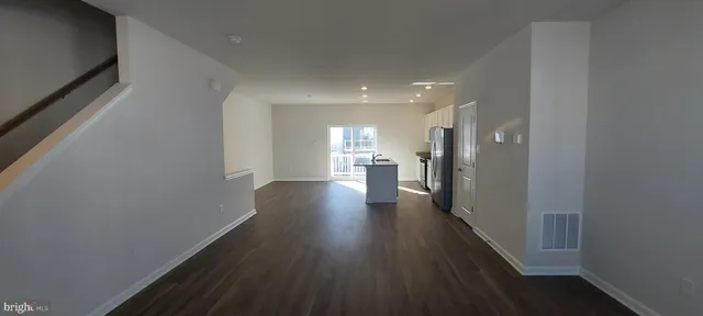 a kitchen with stainless steel appliances a refrigerator and wooden floor