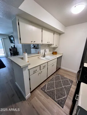 a room with a sink wooden floor and utility