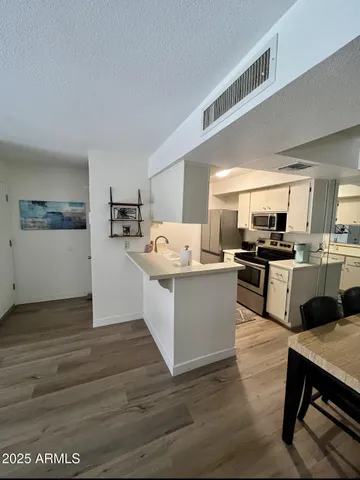 a kitchen with a refrigerator and a stove top oven