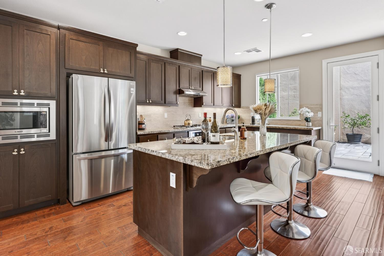 360 Gerald Circle Milpitas, CA 95035 - Photo 9 of 46 a kitchen with stainless steel appliances granite countertop a refrigerator a stove a sink a dining table and chairs with wooden floor