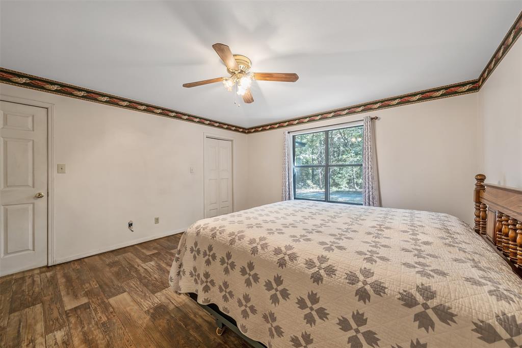 2026 County Road 3234 Quitman, TX 75783 - Photo 28 of 36 Master bedroom featuring LVP flooring, a ceiling fan, and two closets