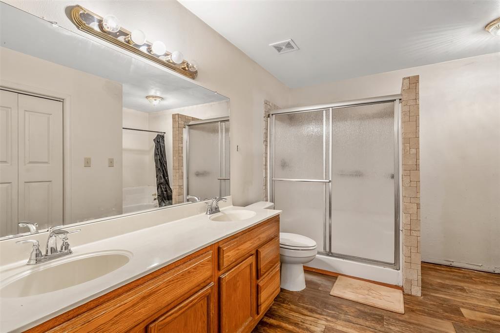 2026 County Road 3234 Quitman, TX 75783 - Photo 30 of 36 Master bath with LVP flooring, double vanity, and a shower stall