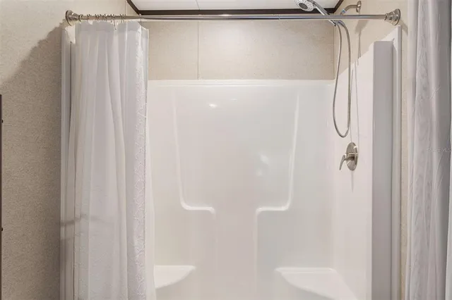 a bathroom with a shower and a glass door
