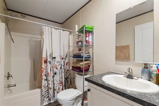 a bathroom with a granite countertop sink a toilet and shower