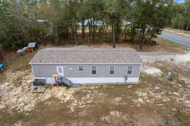 an aerial view of a house with backyard space and balcony