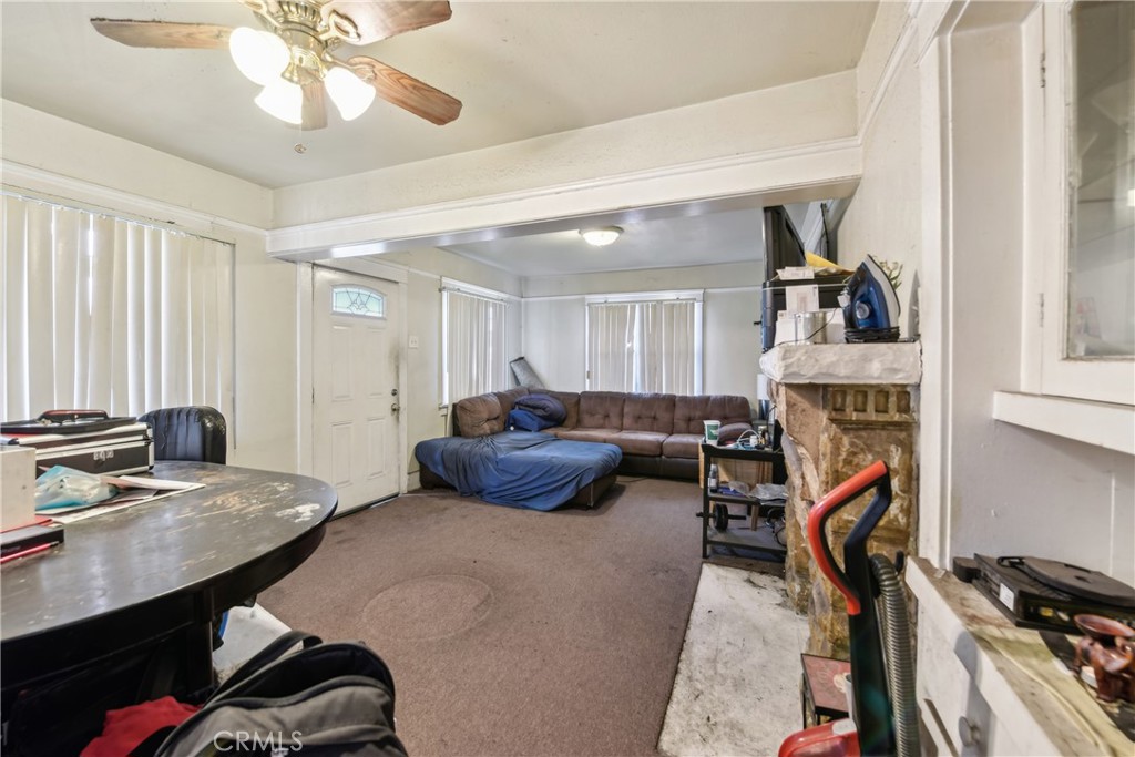 231 West 88th Street Los Angeles, CA 90003 - Photo 7 of 15 a living room with furniture a fireplace and a flat screen tv