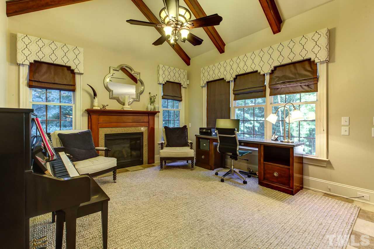1420 Wynncrest Court Raleigh, NC 27603 - Photo 14 of 30 a living room with furniture a flat screen tv and a fireplace