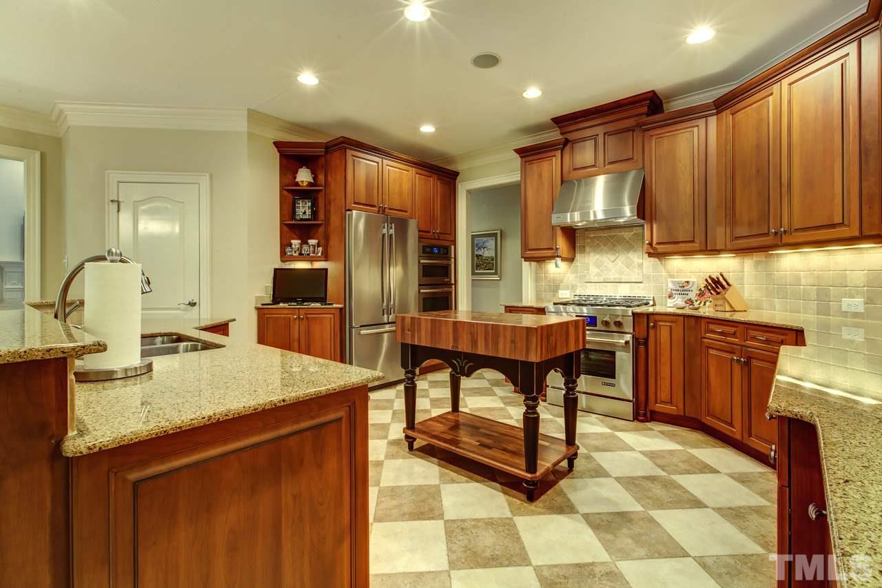 1420 Wynncrest Court Raleigh, NC 27603 - Photo 8 of 30 a kitchen with kitchen island granite countertop a sink counter top space appliances and cabinets