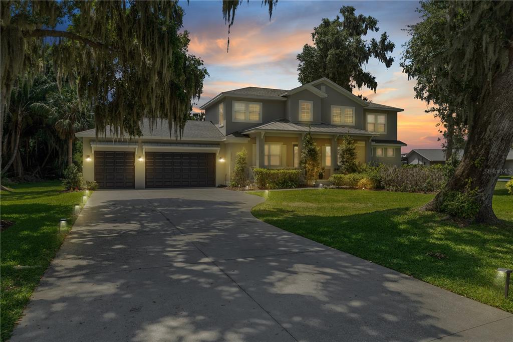 16948 Deer Island Road Tavares, FL 32778 - Photo 64 of 67 a front view of a house with a garden and trees