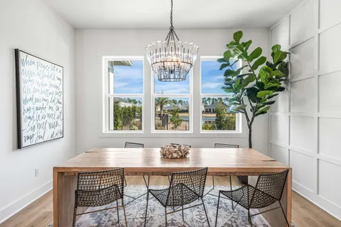 a dining room with furniture a chandelier and window