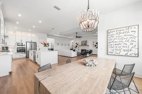 a very nice looking dining room with kitchen island furniture wooden floor and a chandelier