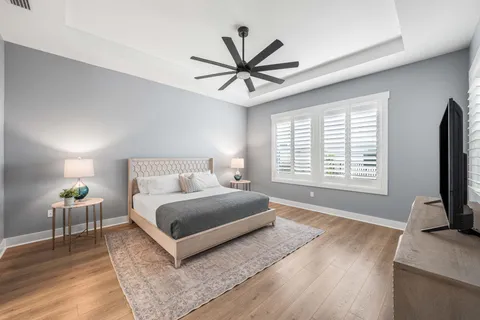 a spacious bedroom with a bed a window and a flat screen television