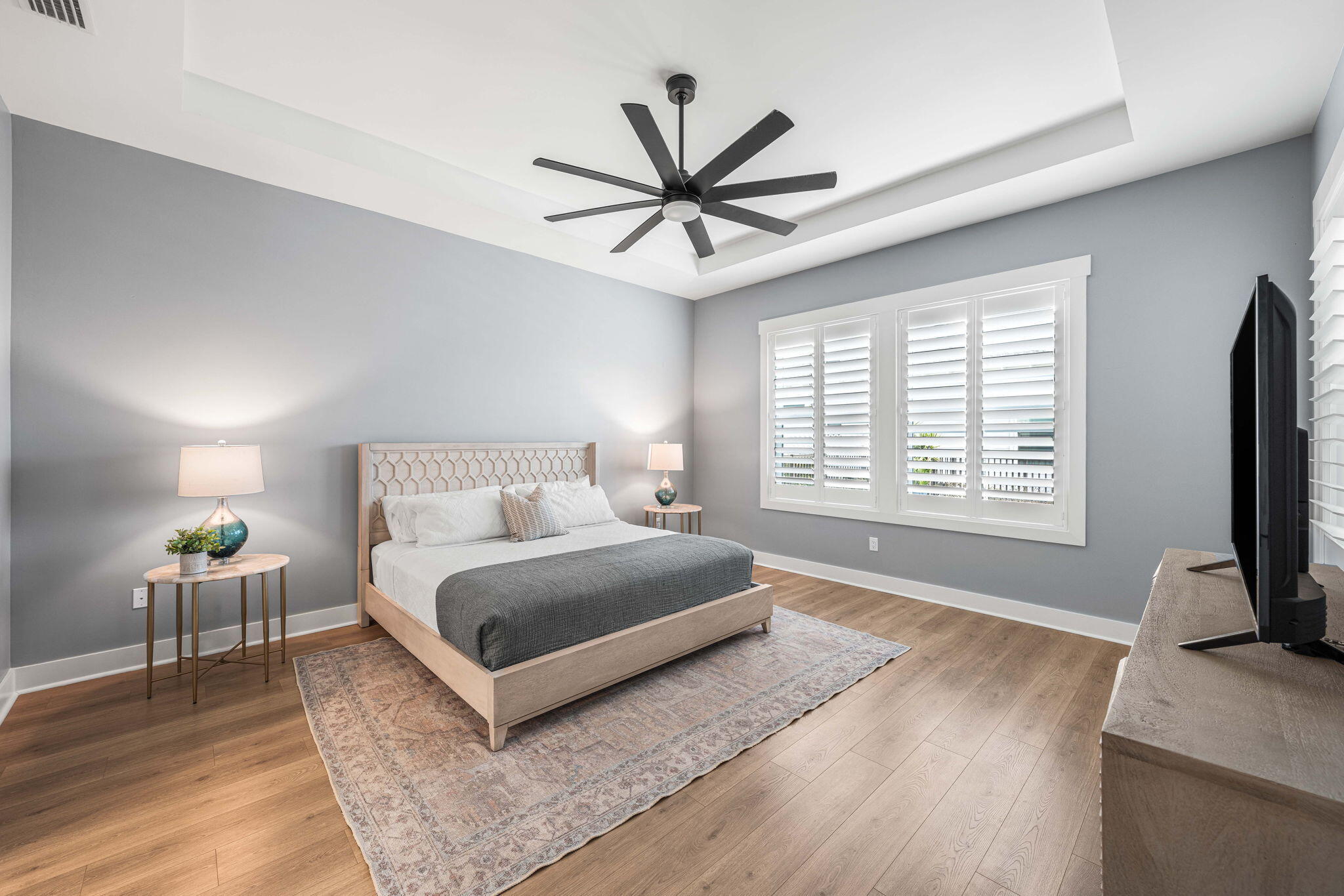 425 Lafayette Road Watersound, FL 32461 - Photo 19 of 52 a spacious bedroom with a bed a window and a flat screen television