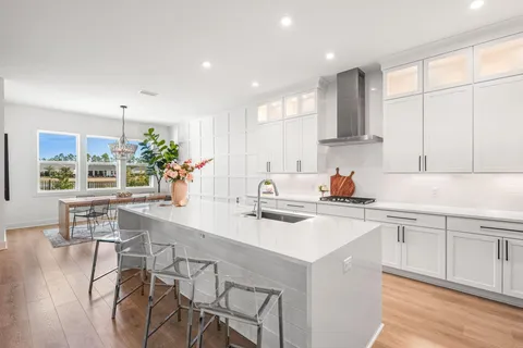 a kitchen with a table chairs stove and cabinets