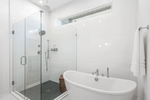 a white bath tub sitting next to a white sink and a shower