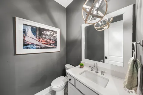 a bathroom with a sink vanity mirror and toilet