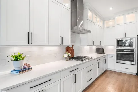 a kitchen with stainless steel appliances white cabinets and a stove