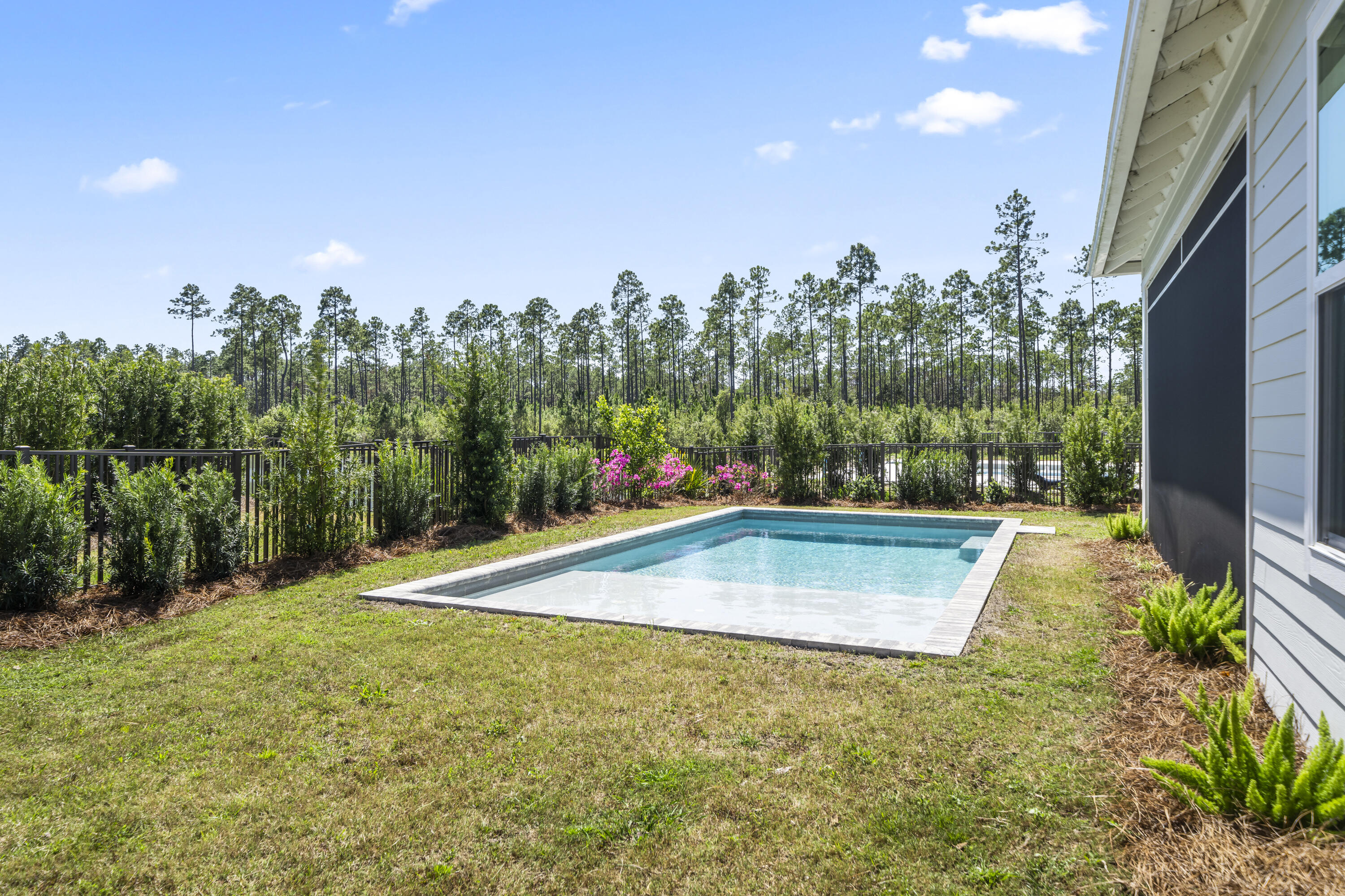 425 Lafayette Road Watersound, FL 32461 - Photo 50 of 52 a view of a swimming pool with an outdoor seating and a garden
