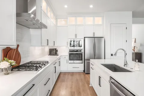 a kitchen with stainless steel appliances a sink stove and refrigerator