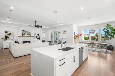 a large white kitchen with cabinets a sink and appliances