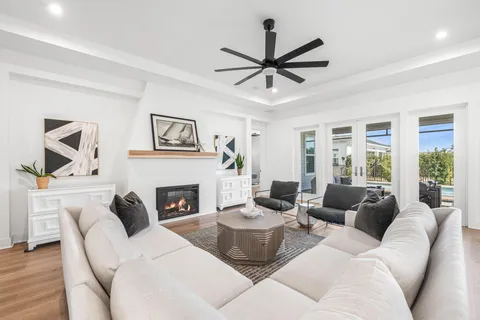 a living room with furniture a fireplace and a large window