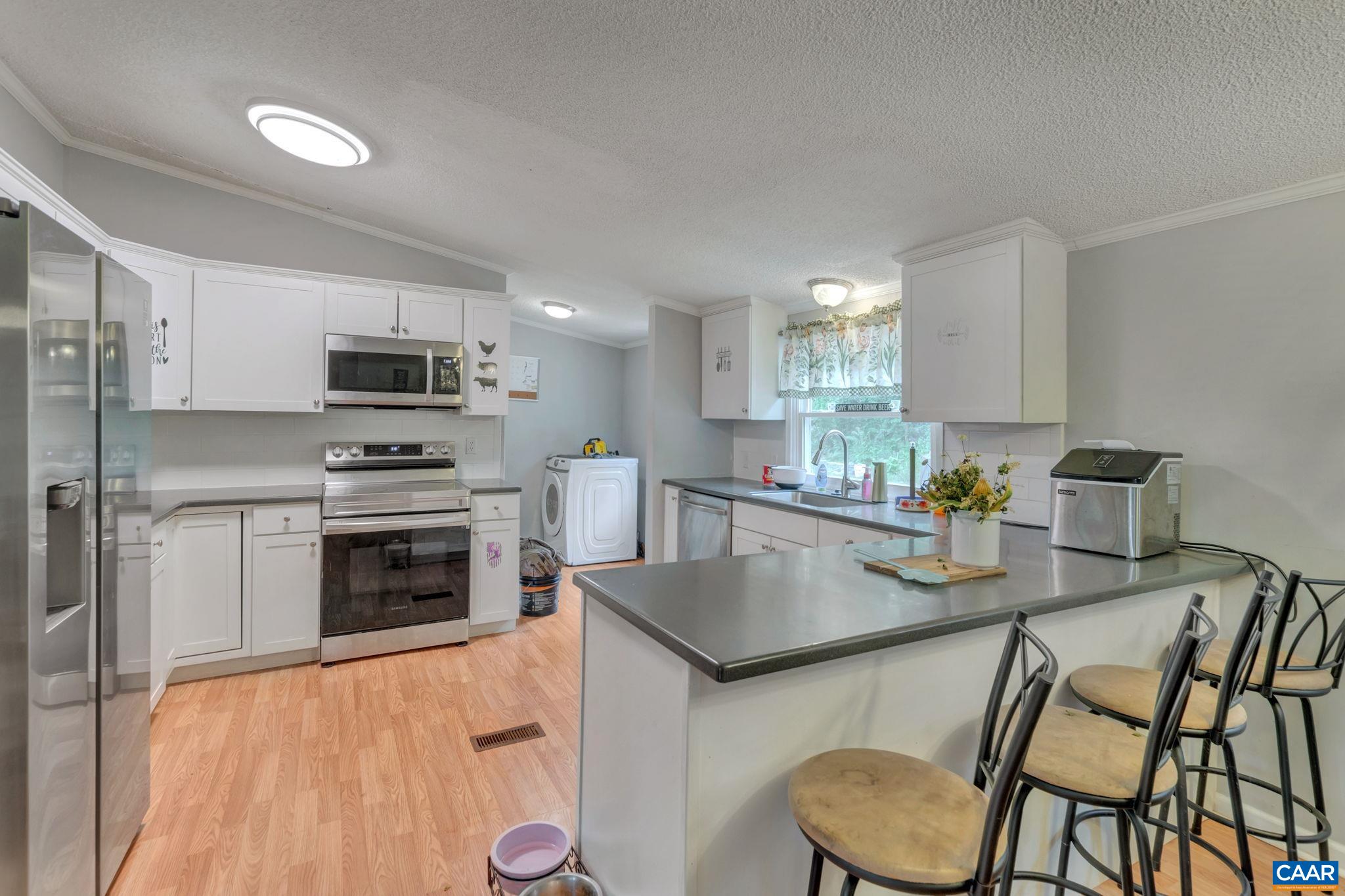 1826 Adial Road Faber, VA 22938 - Photo 15 of 39 a kitchen with kitchen island granite countertop a sink cabinets and stainless steel appliances