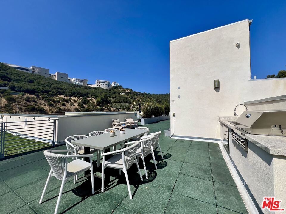 11715 Bellagio Road, Unit 204 Los Angeles, CA 90049 - Photo 24 of 27 a view of a kitchen with a table and chairs