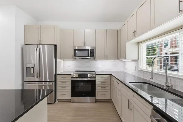 a kitchen with stainless steel appliances granite countertop a stove a sink and a refrigerator