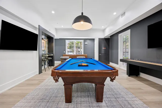 a room with pool table flat screen tv and windows