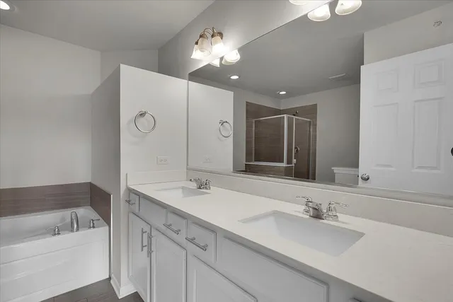 a bathroom with a sink double vanity granite tub and a mirror