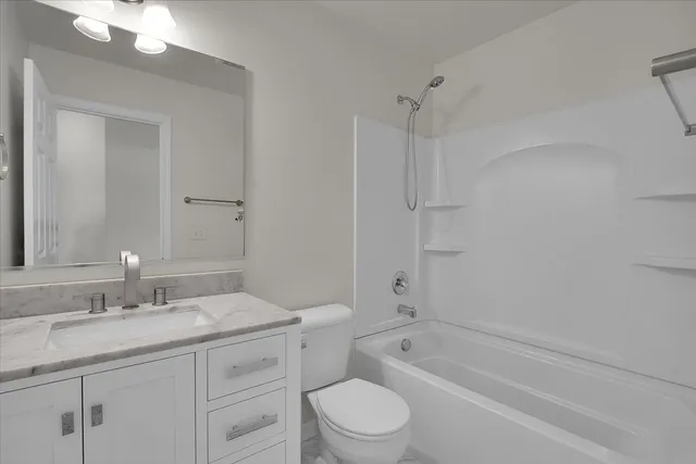 a bathroom with a granite countertop sink a toilet and shower