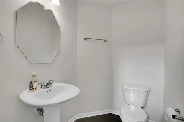 a bathroom with a toilet a sink and mirror