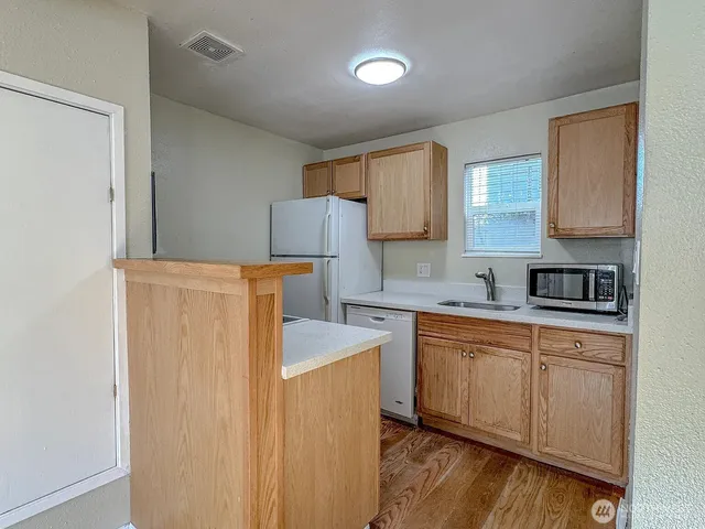 a kitchen with a refrigerator sink and cabinets